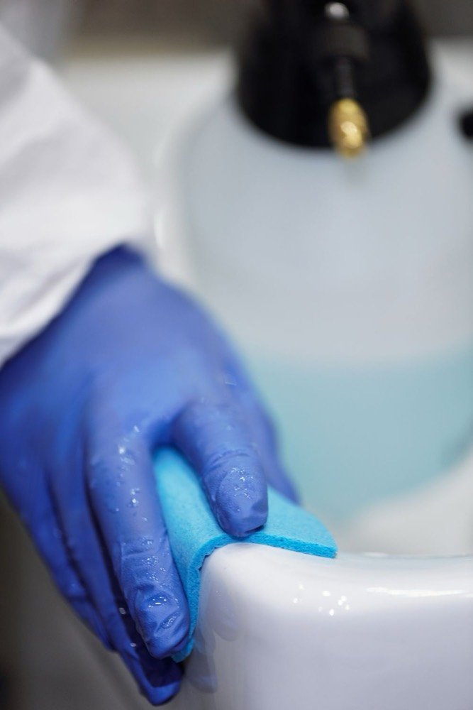 Hygienische Reinigung mit Handschuhen in einer Praxis – Praxisreinigung
